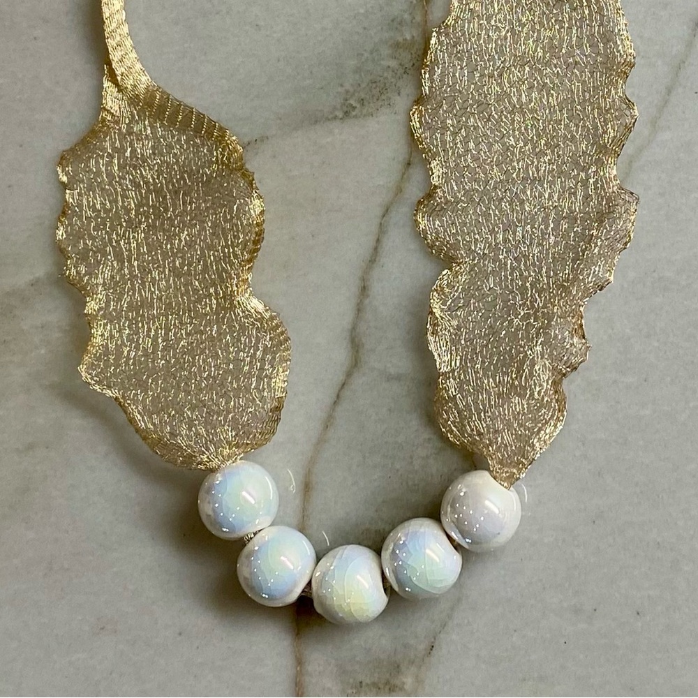 Necklace of white gold netting ribbon and pearl white crackle ceramic beads